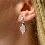 A model wearing Juraster’s Sterling Silver Rose Quartz Earring Charm, Adventure, crafted from Fairmined sterling silver and a hand-cut rose quartz attached to a matching earring stud.