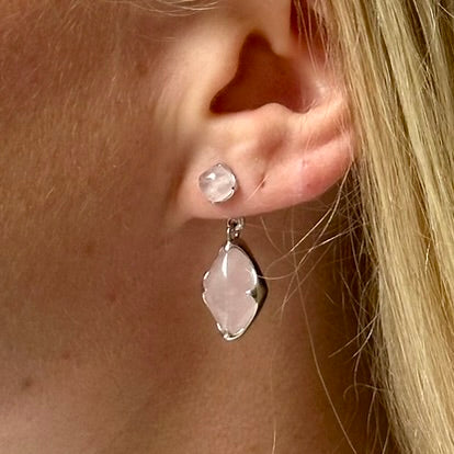 A model wearing Juraster’s Sterling Silver Rose Quartz Earring Charm, Adventure, crafted from Fairmined sterling silver and a hand-cut rose quartz attached to a matching earring stud.