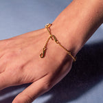 A model wearing Juraster's 9ct Gold Rainbow Moonstone Adjustable Bracelet, Three Wishes, crafted from Fairmined 9ct yellow gold and hand-cut rainbow moonstones.
